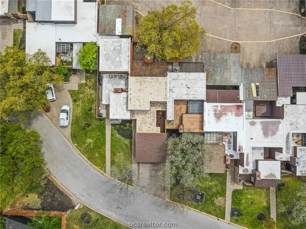 an aerial view of residential houses with outdoor space and street view