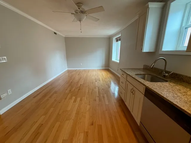 a kitchen with a sink and wooden floor
