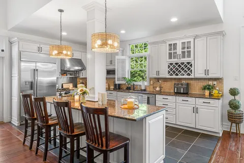 a kitchen with a dining table chairs sink and cabinets