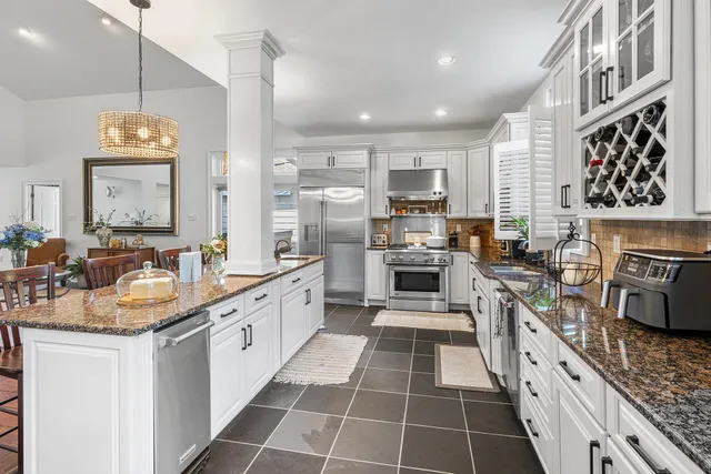 a large kitchen with stainless steel appliances a stove sink and cabinets