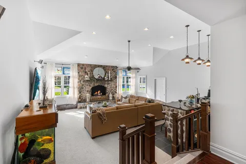 a living room with furniture a fireplace and a chandelier