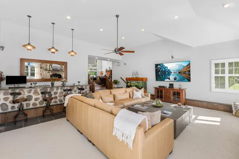 a living room with furniture kitchen view and a wooden floor