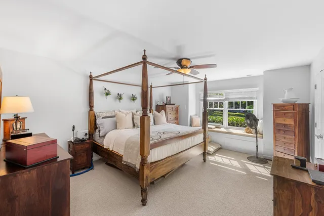 a white bed sitting in a room next to a window
