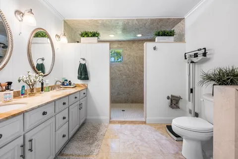 a bathroom with a granite countertop sink mirror and toilet
