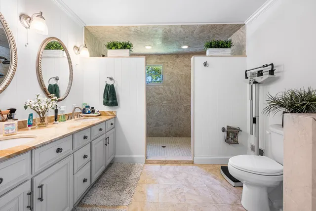 a bathroom with a granite countertop sink mirror and toilet