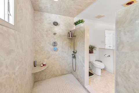 a bathroom with a toilet and a shower