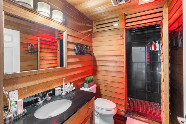 a bathroom with a sink a toilet and shower