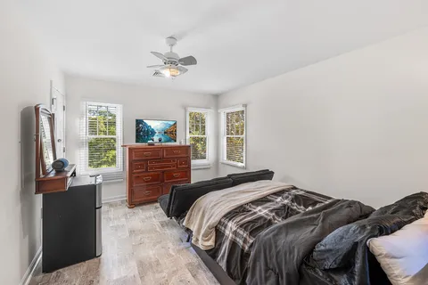a bedroom with a bed and wooden floor