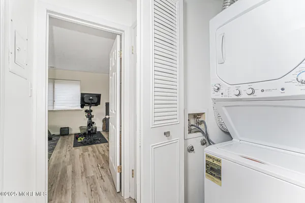 a view of washer and dryer with bathroom in the background