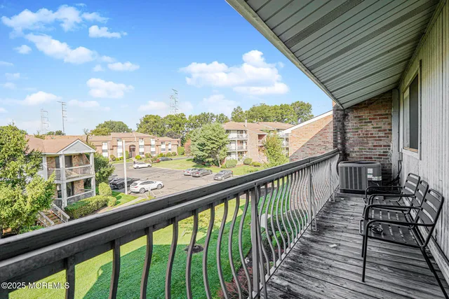 a view of a balcony with wooden floor & fence
