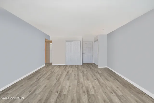 a view of an empty room with wooden floor