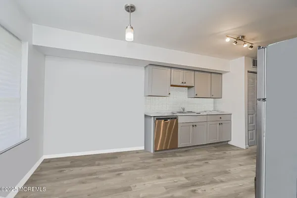 a big room with chandelier fan and kitchen view