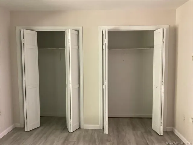 an empty room with wooden floor and closet