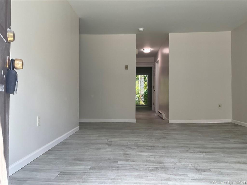1271 Washington Street, Unit 5 Middletown, CT 06457 - Photo 7 of 19 a view of an empty room with wooden floor and a window