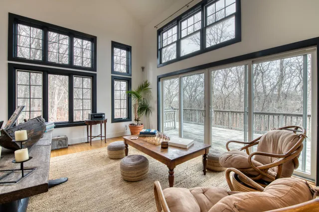 a living room with furniture and floor to ceiling windows