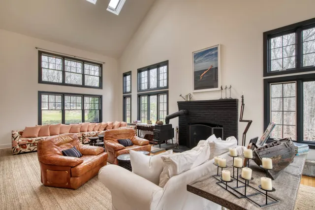 a living room with furniture fireplace and a large window