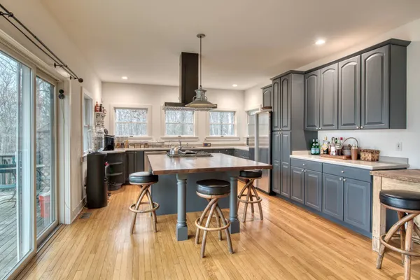 a kitchen with stainless steel appliances kitchen island granite countertop a table chairs sink and cabinets
