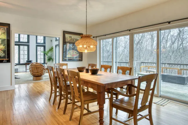 a view of a dining room with furniture large windows and wooden floor