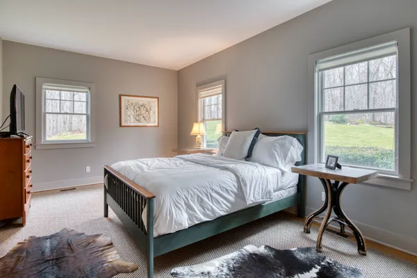 a bedroom with a bed window and chair