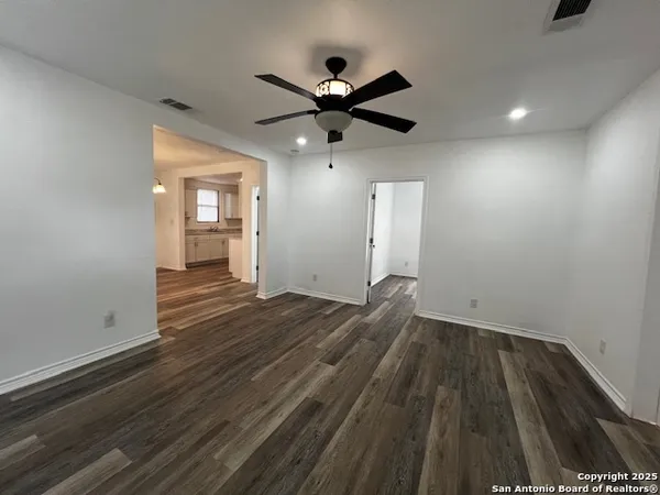 a view of empty room with wooden floor