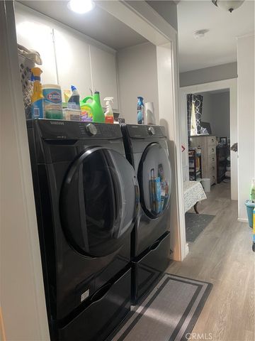 a utility room with wooden floor washer and dryer