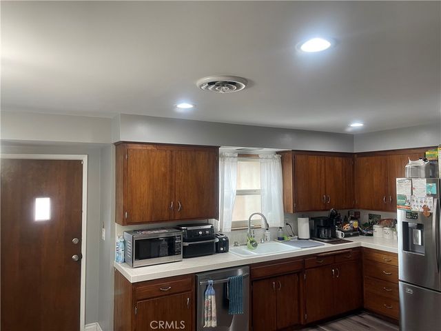 a kitchen with a sink a stove cabinets and a window