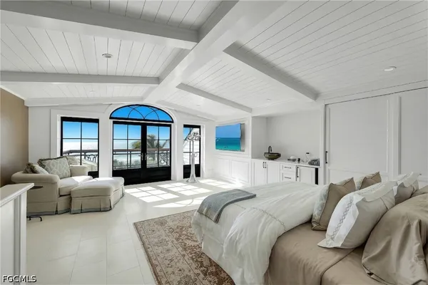 a bedroom with a large bed couch and a large window
