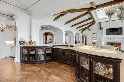 a living room with stainless steel appliances granite countertop a stove and a sink