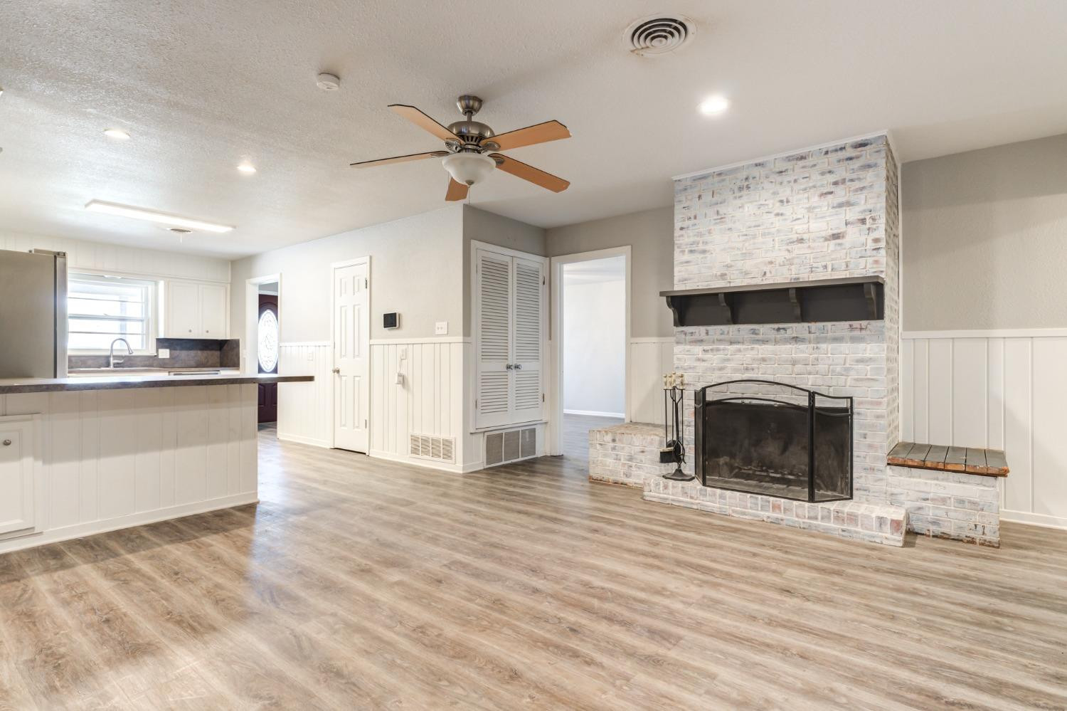 4409 49th Street Lubbock, TX 79414 - Photo 19 of 49 a view of a livingroom with a fireplace a ceiling fan and wooden floor