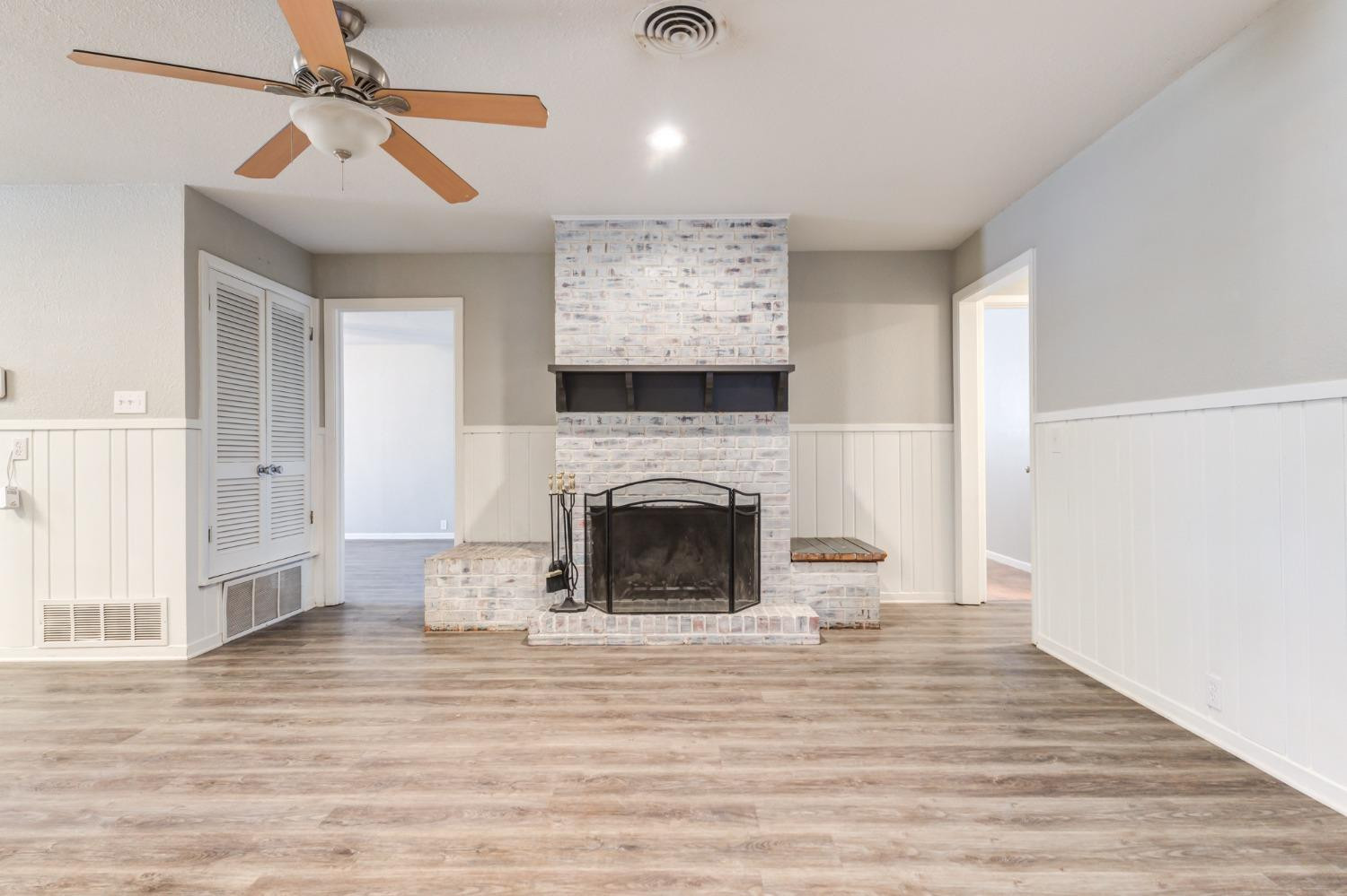 4409 49th Street Lubbock, TX 79414 - Photo 20 of 49 a view of a livingroom with a fireplace a chandelier and wooden floor