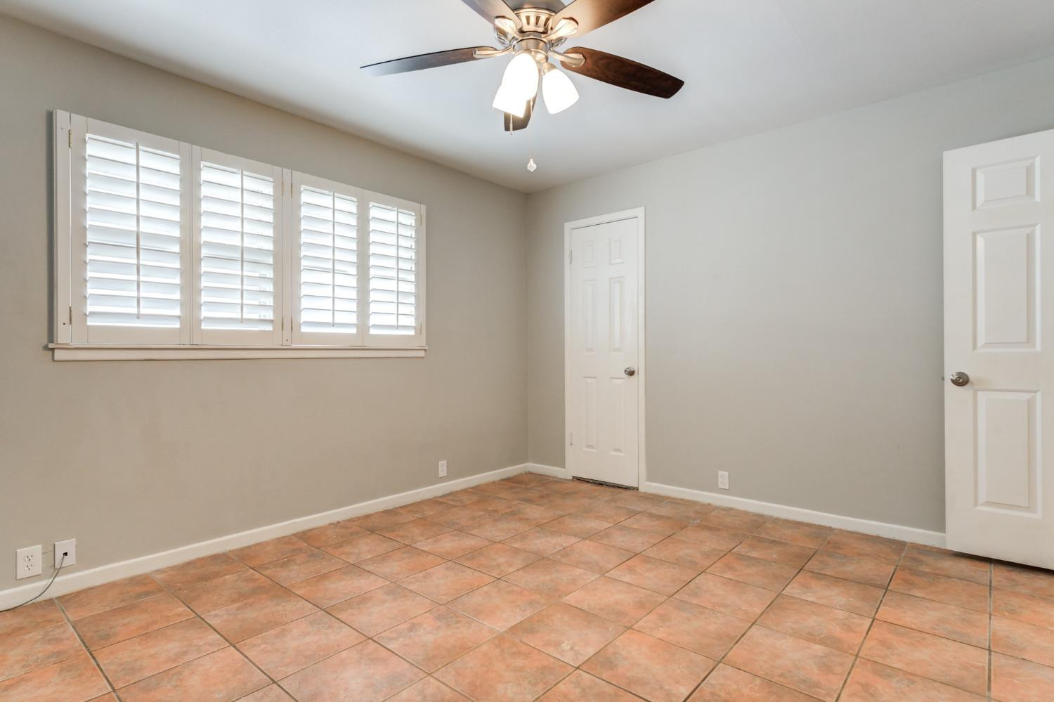 4409 49th Street Lubbock, TX 79414 - Photo 25 of 49 a view of an empty room with window and chandelier fan