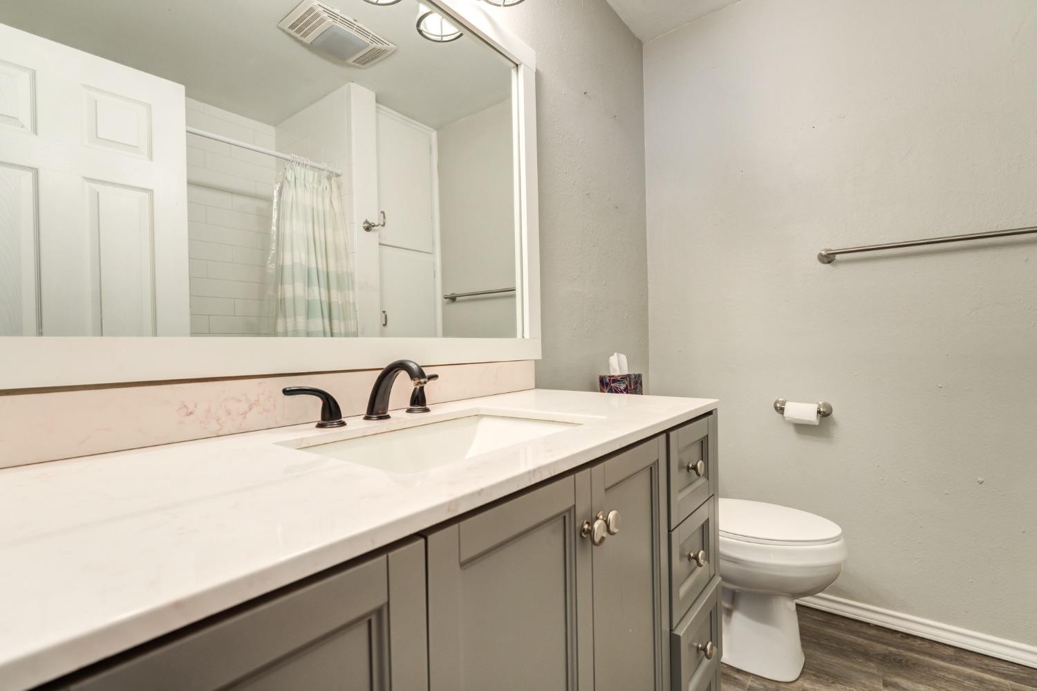 4409 49th Street Lubbock, TX 79414 - Photo 26 of 49 a bathroom with a sink toilet and a mirror
