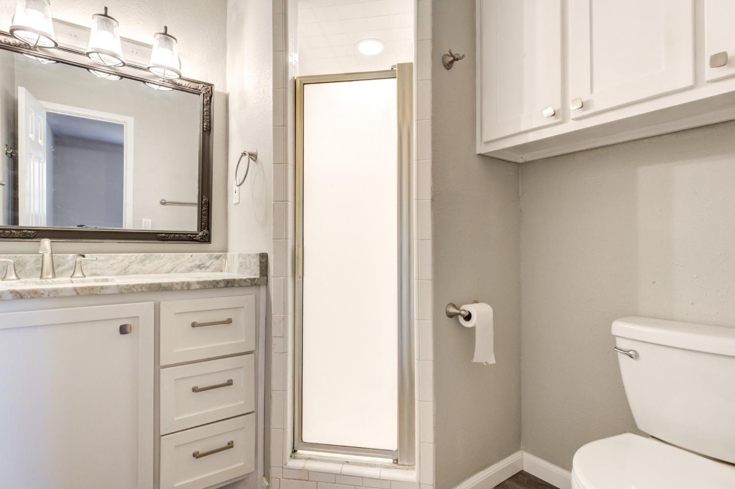 4409 49th Street Lubbock, TX 79414 - Photo 35 of 49 a bathroom with a granite countertop toilet sink and mirror