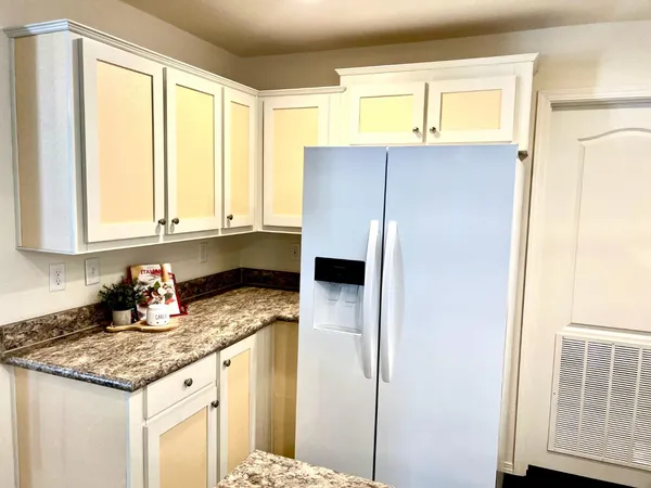 a kitchen with stainless steel appliances granite countertop a sink and a refrigerator