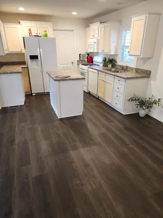 a kitchen with cabinets and wooden floor