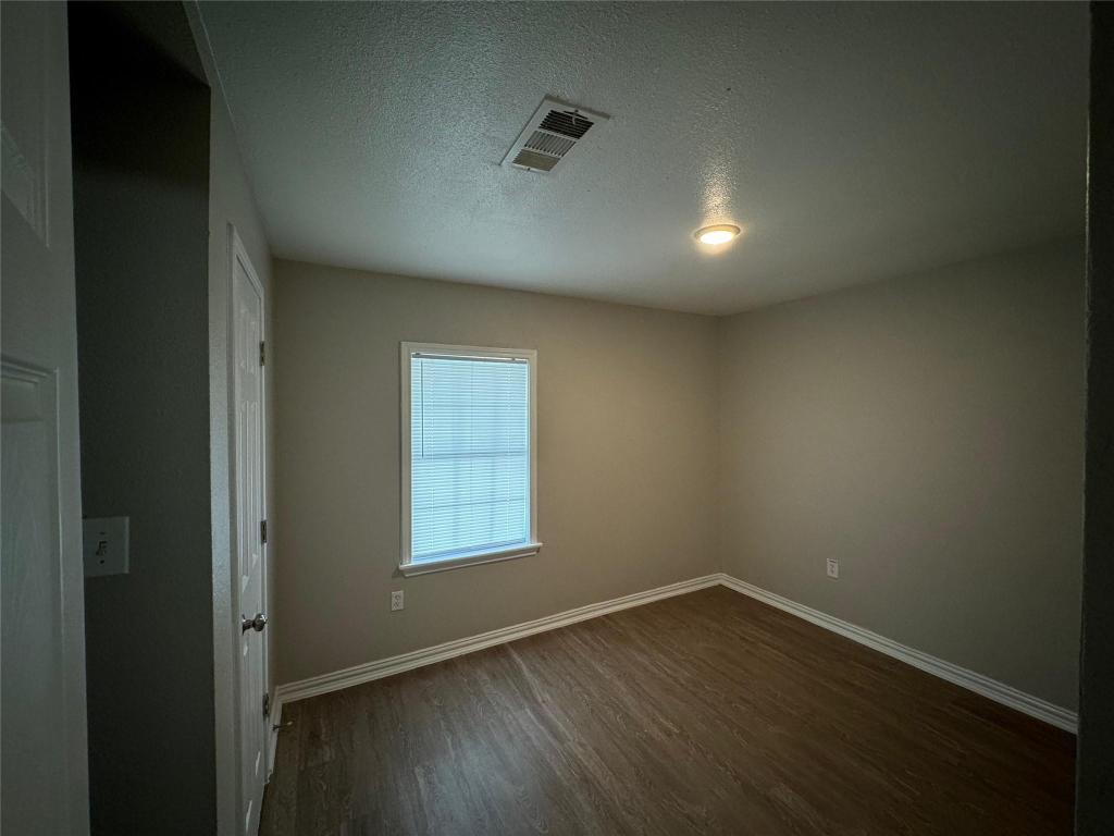 101 South Lockhart Street, Unit A Manor, TX 78653 - Photo 13 of 21 an empty room with wooden floor and windows