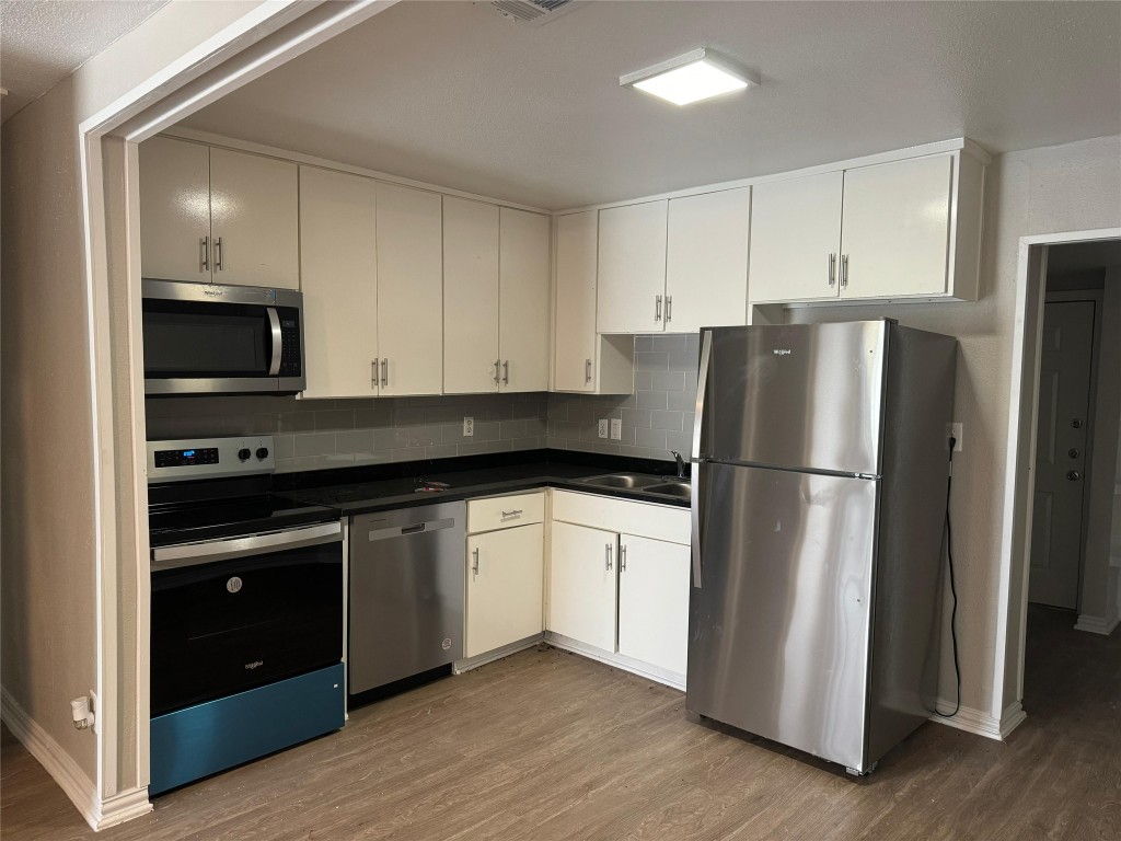 101 South Lockhart Street, Unit A Manor, TX 78653 - Photo 7 of 21 a kitchen with a refrigerator stove and sink