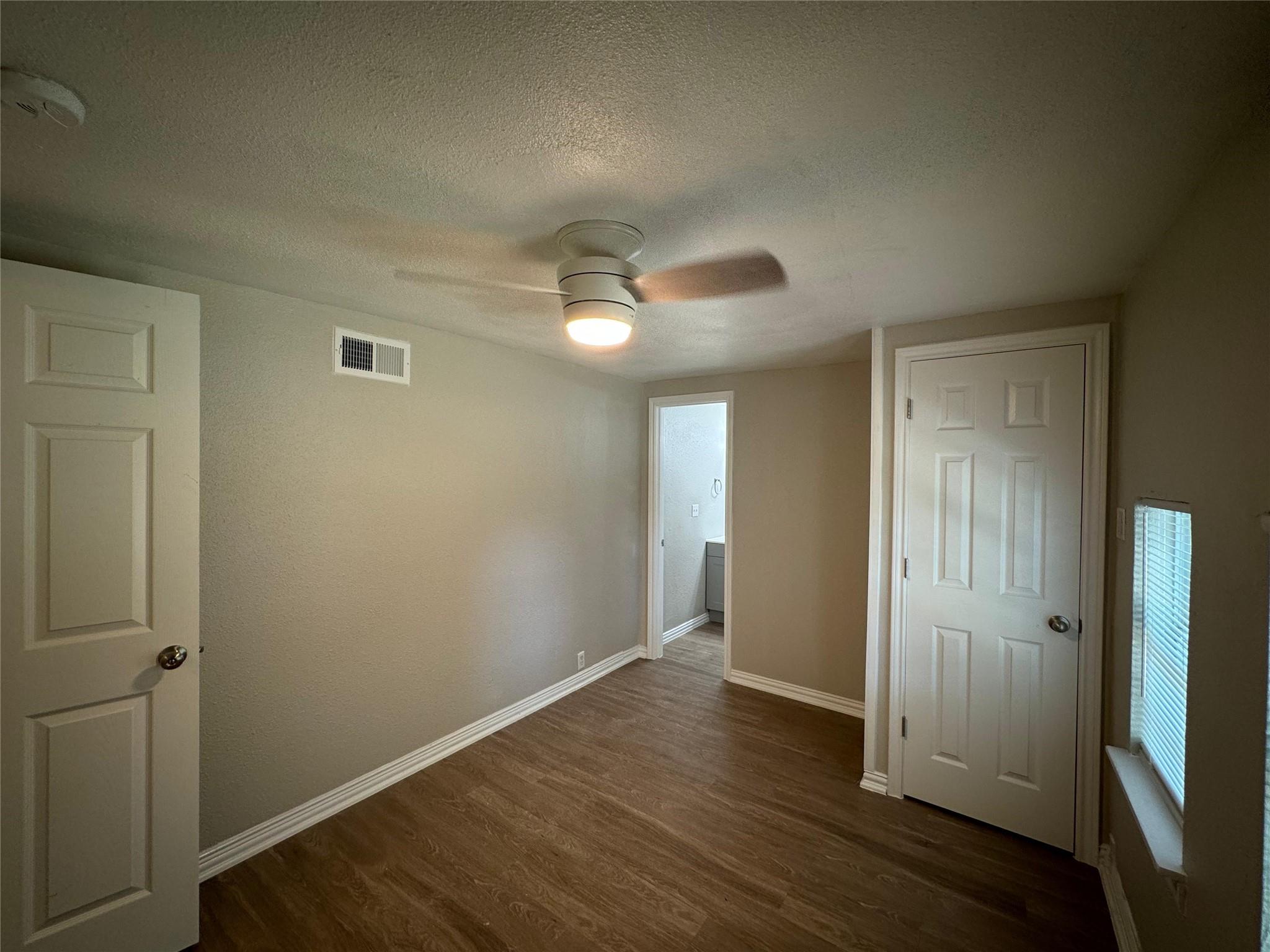 101 South Lockhart Street, Unit A Manor, TX 78653 - Photo 9 of 21 an empty room with wooden floor and a ceiling fan