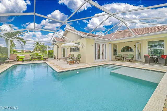 a large white building with a swimming pool and yard