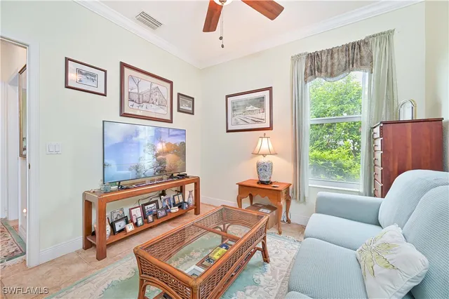 a living room with furniture a window and a flat screen tv