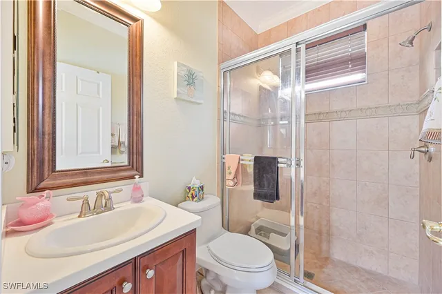 a bathroom with a sink toilet vanity and shower