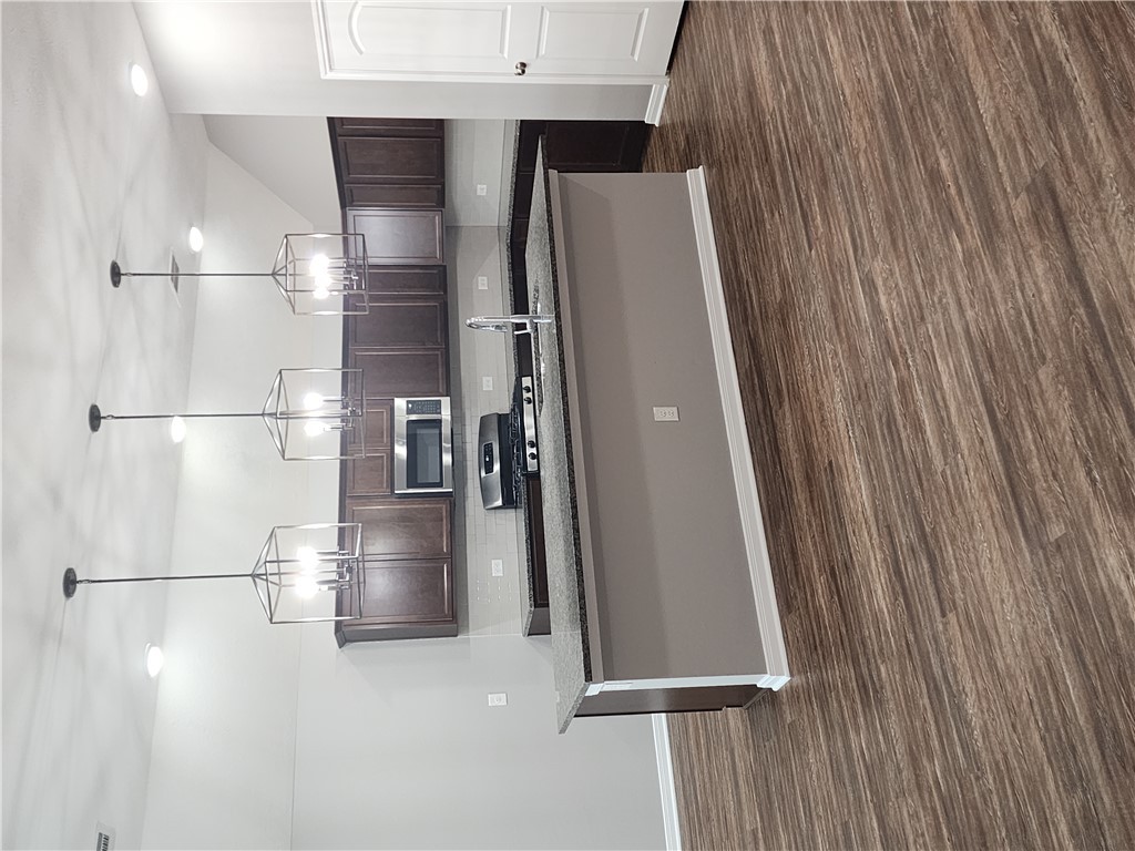4015 Dunlap Loop College Station, TX 77845 - Photo 7 of 40 a kitchen with stainless steel appliances granite countertop a sink a stove and a wooden floor