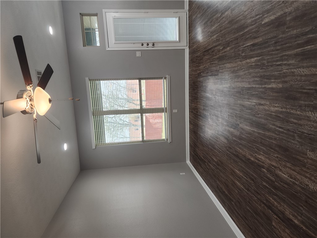 4015 Dunlap Loop College Station, TX 77845 - Photo 9 of 40 an empty room with wooden floor chandelier fan and windows