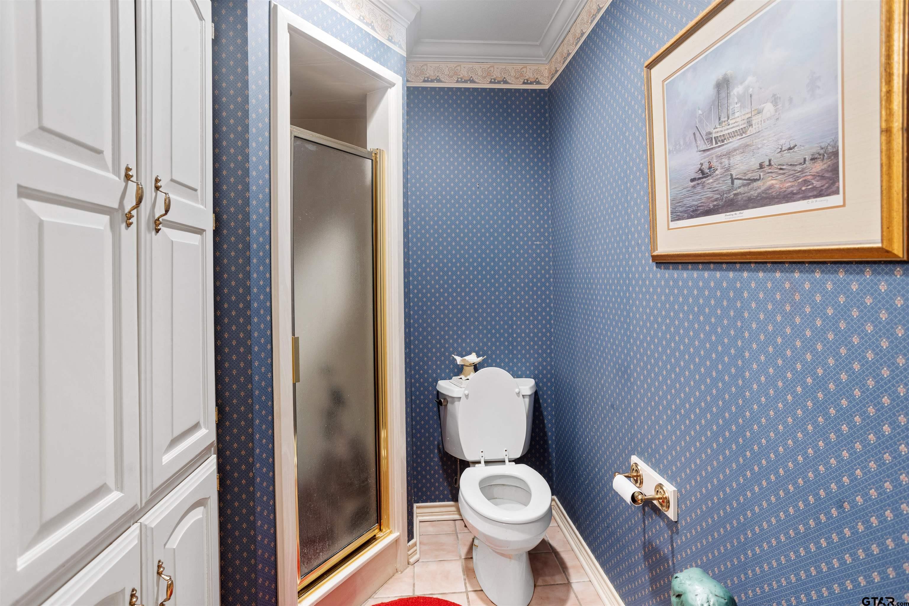 1701 Tall Timber Drive Flint, TX 75762 - Photo 33 of 40 a bathroom with a toilet and a painting on the wall