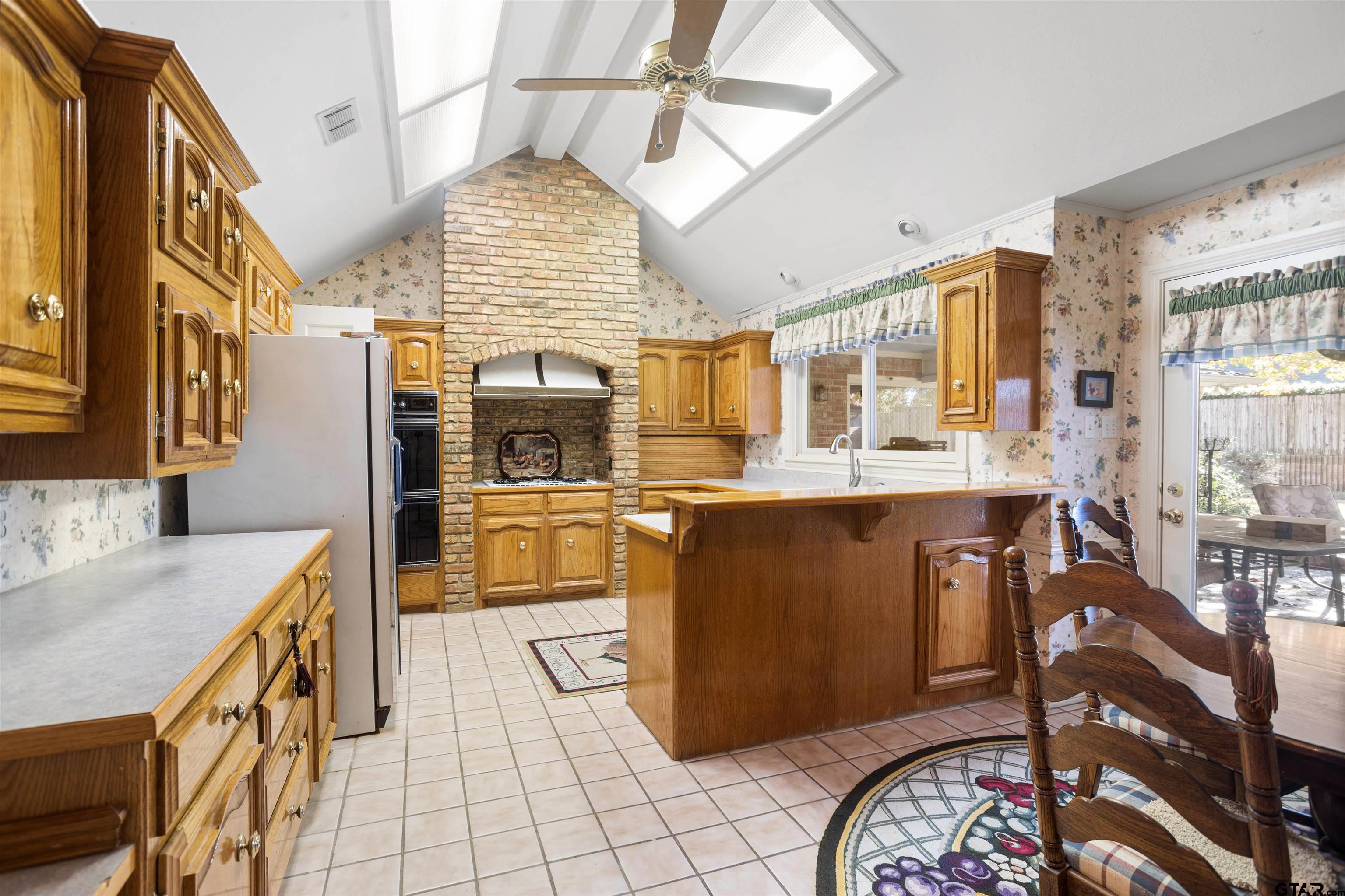 1701 Tall Timber Drive Flint, TX 75762 - Photo 9 of 40 a kitchen with stainless steel appliances kitchen island granite countertop a sink and cabinets
