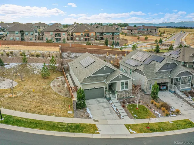 an aerial view of residential houses with outdoor space and ocean view