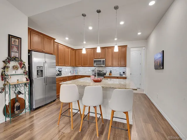 a kitchen with refrigerator a table and chairs