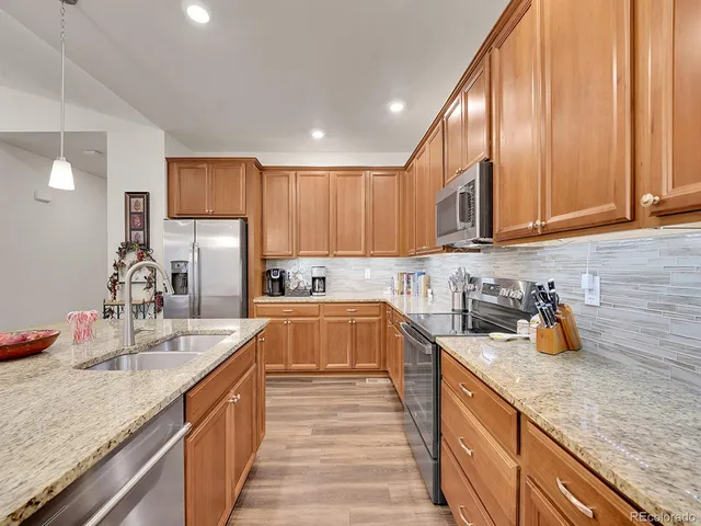a kitchen with stainless steel appliances granite countertop a sink stove and refrigerator