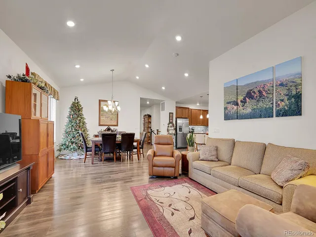 a living room with furniture kitchen view and a large window