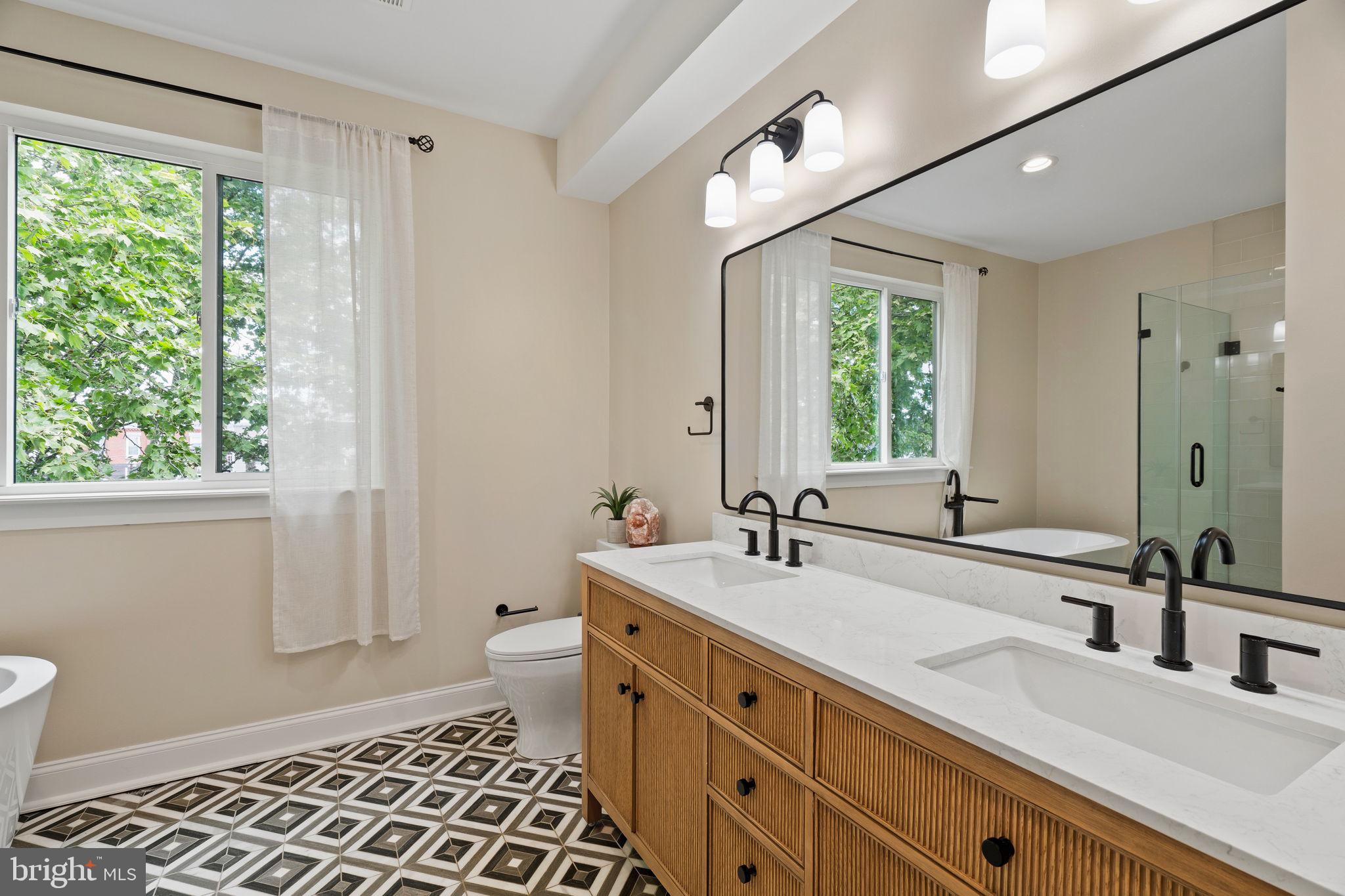 2932 Nicholas Street Philadelphia, PA 19121 - Photo 32 of 65 a bathroom with a double vanity sink toilet and a mirror